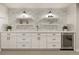 Finished basement bar area with stylish backsplash, shelving, cabinets, and beverage cooler at 6248 S Coventry Ln, Littleton, CO 80123