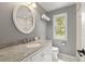 Well-lit bathroom featuring granite countertop and decorative oval mirror at 6248 S Coventry Ln, Littleton, CO 80123