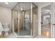Modern bathroom with glass-enclosed shower, stone accents, and tiled floors at 6248 S Coventry Ln, Littleton, CO 80123