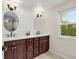 Bathroom features a double vanity with two mirrors, white walls, and a window that provides natural light at 6248 S Coventry Ln, Littleton, CO 80123