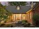 Inviting covered front porch with a wooden bench and stone pathway surrounded by lush landscaping and charming exterior lights at 6248 S Coventry Ln, Littleton, CO 80123