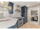 A kitchen featuring blue cabinets, stainless steel appliances, and a herringbone backsplash at 6248 S Coventry Ln, Littleton, CO 80123