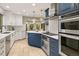 Spacious kitchen featuring white and navy cabinetry, stainless appliances, and tile flooring at 6248 S Coventry Ln, Littleton, CO 80123