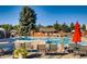 Community pool with clear blue water, brick fencing, mature trees, and lounge seating creating a relaxing outdoor space at 6248 S Coventry Ln, Littleton, CO 80123