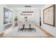 Bright dining room with large window, modern light fixture, and light wood flooring at 872 S Vine St, Denver, CO 80209