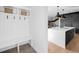 Entryway with coat rack and bench, leading to modern kitchen with island and staircase at 872 S Vine St, Denver, CO 80209