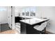 Modern kitchen with sleek countertops, black cabinets, bar seating and large windows at 872 S Vine St, Denver, CO 80209