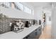 Kitchen counter featuring coffee and espresso machine, black cabinets, and patterned backsplash at 872 S Vine St, Denver, CO 80209