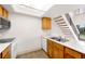 Open kitchen features skylight, wood cabinets, white appliances, and adjacent staircase at 4896 S Dudley St # 8-11, Littleton, CO 80123