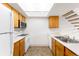 Bright kitchen with skylight, white appliances, wood cabinets, and staircase at 4896 S Dudley St # 8-11, Littleton, CO 80123