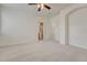 Spacious carpeted bedroom with neutral colors, ceiling fan, closet, and bathroom entrance at 16051 E Geddes Dr # 66, Aurora, CO 80016