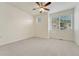 Bright, carpeted bedroom with a ceiling fan and natural light from the window at 16051 E Geddes Dr # 66, Aurora, CO 80016