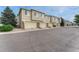 Row of townhomes with attached garages and mature trees lining the street in a well-maintained community at 16051 E Geddes Dr # 66, Aurora, CO 80016