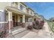 Charming townhome with a covered front porch, brick accents, and landscaped front yard at 16051 E Geddes Dr # 66, Aurora, CO 80016