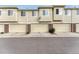 A row of townhome garages featuring a cream color, brick accents, and visible unit numbers for easy identification at 16051 E Geddes Dr # 66, Aurora, CO 80016