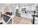 Modern kitchen boasting white cabinetry, stainless steel appliances, and ample counter space, with access to the dining area at 365 W Peakview Ave, Littleton, CO 80120