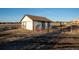 Charming white barn featuring brown trim accents and functional sliding doors at 10353 N Chatfield Dr, Littleton, CO 80125