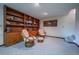 Finished basement has custom wood shelves and cabinets, seating and blue carpeting at 10353 N Chatfield Dr, Littleton, CO 80125