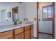 Bathroom vanity features wood cabinets, a large mirror and a separated room with a shower at 10353 N Chatfield Dr, Littleton, CO 80125