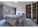 Comfortable bedroom with built-in shelving and a large window offering natural light at 10353 N Chatfield Dr, Littleton, CO 80125