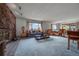 Bright living room featuring stone fireplace, carpet floors, and large windows at 10353 N Chatfield Dr, Littleton, CO 80125