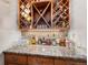 Stylish bar area with a custom wine rack, granite countertop, and ample space for entertaining guests at 2091 Ramblewood Ct, Castle Rock, CO 80104