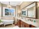 Bright bathroom with a standalone tub, dual vanities, and a large window at 2091 Ramblewood Ct, Castle Rock, CO 80104
