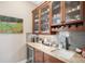 Butler's pantry with granite countertops, dark wood cabinets, wine cooler, and subway tile backsplash at 2091 Ramblewood Ct, Castle Rock, CO 80104