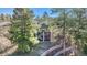 Aerial backyard view of a multi-story home with a stone facade, multiple balconies, and a landscaped backyard at 2091 Ramblewood Ct, Castle Rock, CO 80104