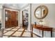 Elegant foyer with a wood front door, decorative mirror, and stylish table at 2091 Ramblewood Ct, Castle Rock, CO 80104