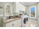 Bright laundry room featuring white cabinets, modern washer and dryer, and a window for natural light at 2091 Ramblewood Ct, Castle Rock, CO 80104