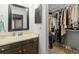 Bright bathroom with modern vanity, large mirror, and nearby closet at 2306 S Troy St # A, Aurora, CO 80014