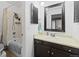 Bathroom features a shower-tub combo, neutral finishes, and black framed mirror at 2306 S Troy St # A, Aurora, CO 80014