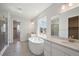 Luxurious bathroom features a soaking tub, dual sinks, tile flooring, and a large window at 13900 Hanging Lake St, Parker, CO 80138