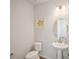 Well-lit half bathroom featuring a pedestal sink, decorative mirror, and simple modern design at 13900 Hanging Lake St, Parker, CO 80138