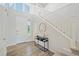 Bright foyer with wood floors, white staircase, a stylish console table, and large windows at 13900 Hanging Lake St, Parker, CO 80138