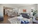 Inviting living room with wood floors, modern furnishings, and an open view to the kitchen and dining area at 13900 Hanging Lake St, Parker, CO 80138