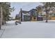 Contemporary home with gray siding and wood accents, snowy yard at 7250 N Hyperion Way, Parker, CO 80134