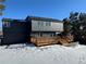 Two-story dark gray house with a wooden deck and snowy yard at 7250 N Hyperion Way, Parker, CO 80134