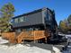 Modern two-story home with gray siding, wooden deck, and snowy landscaping at 7250 N Hyperion Way, Parker, CO 80134