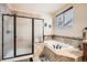 Bathroom featuring a separate shower and soaking tub with tile surround and natural lighting at 15056 Fillmore Way, Thornton, CO 80602