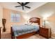 Cozy bedroom with a comfortable bed, nightstands, bedside lamps, a ceiling fan, and carpet flooring at 15056 Fillmore Way, Thornton, CO 80602