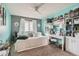 Cozy bedroom with aqua accent wall, white daybed, carpet, and a functional desk area at 15056 Fillmore Way, Thornton, CO 80602