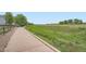 A well-maintained concrete walking path meanders through a green grassy area near the neighborhood homes at 15056 Fillmore Way, Thornton, CO 80602