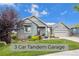 Single-story home with a 3-car tandem garage and landscaped front yard at 6845 W Evans Ave, Denver, CO 80227