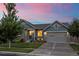 House exterior at dusk showcasing landscaping and a two-car garage at 6845 W Evans Ave, Denver, CO 80227