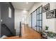 Bright hallway with hardwood floors and a modern glass-paneled door at 6845 W Evans Ave, Denver, CO 80227