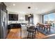 Modern kitchen with stainless steel appliances and an island with seating at 6845 W Evans Ave, Denver, CO 80227