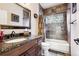 Well-appointed bathroom with granite countertops, dark wood cabinets, and a shower-tub combo with stylish tile at 3305 White Oak Ln, Highlands Ranch, CO 80129