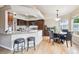 Gourmet kitchen featuring granite countertops, a breakfast bar, stainless appliances, and a dining area at 3305 White Oak Ln, Highlands Ranch, CO 80129